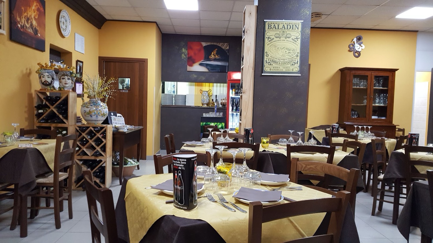 La sala interna con pareti ocra, ceramiche siciliane e teste di moro